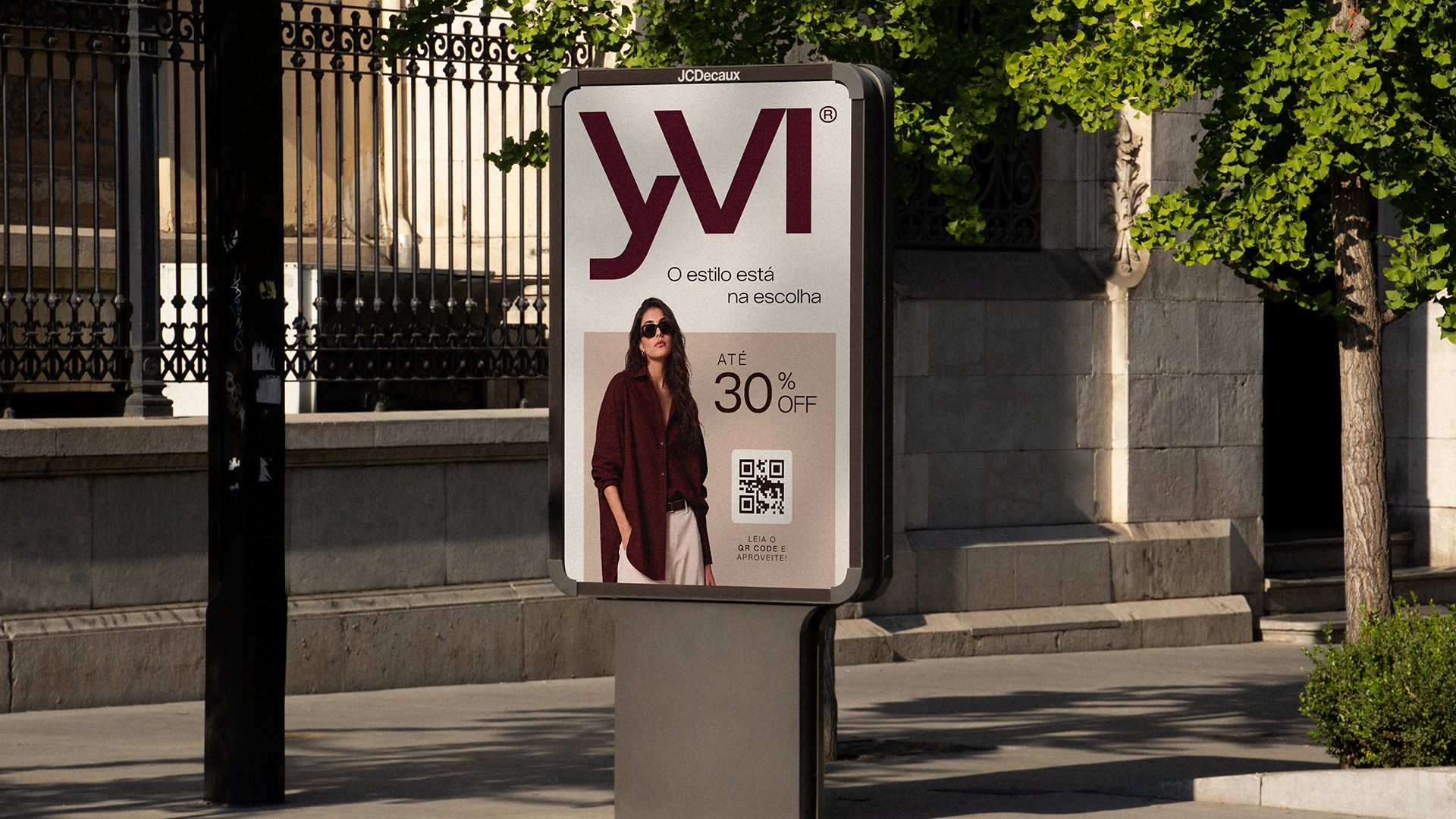 Yvi street advertising display featuring the logo, a fashion model, a 30 percent discount offer and a QR code.